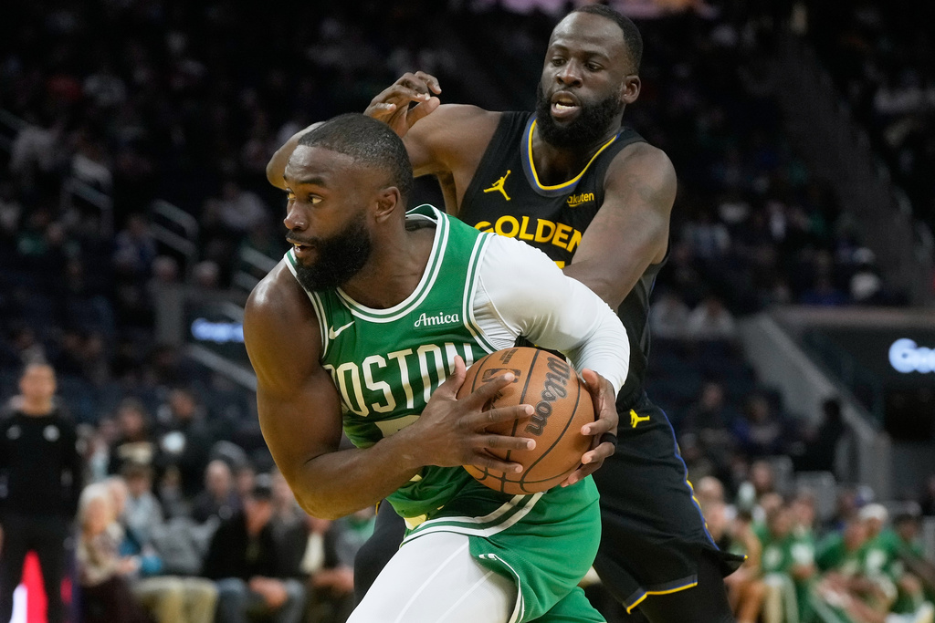 Boston Celtics guard Jaylen Brown, bottom, drives to the basket against Golden State Warriors forward Draymond Green during the second half of an NBA basketball game in San Francisco, Thursday, Feb. 19, 2026. (AP Photo/Jeff Chiu)