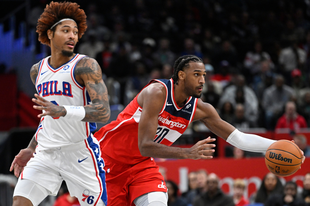 Philadelphia 76ers guard Kelly Oubre Jr., left, watches Washington Wizards center Alex Sarr pass off during the first half of an NBA basketball game Tuesday, Oct. 28, 2025, in Washington. (AP Photo/John McDonnell)