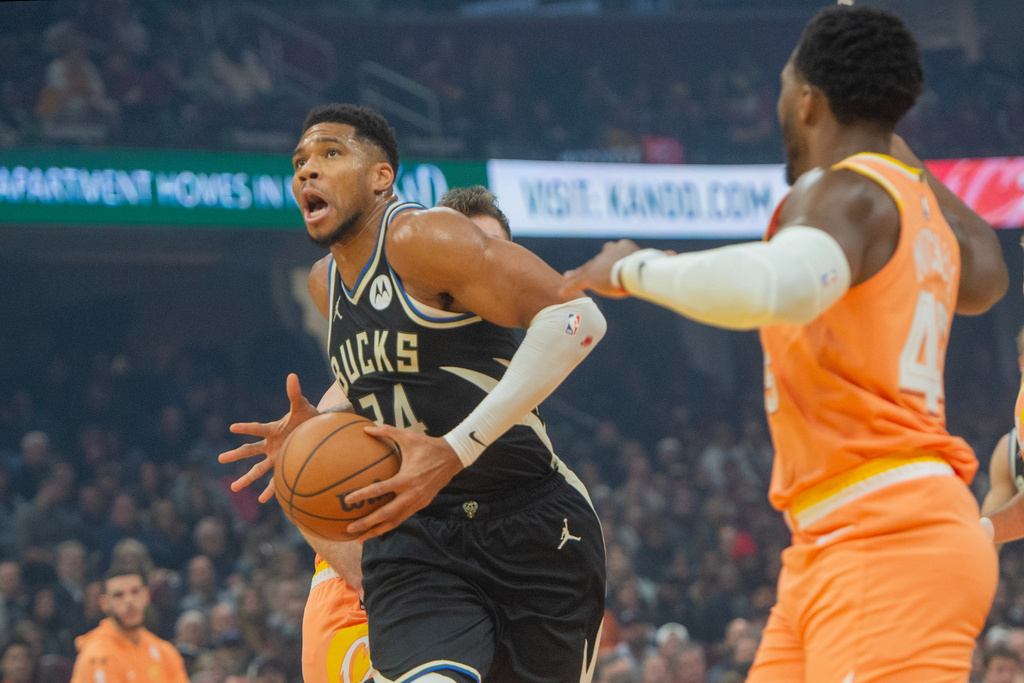 Milwaukee Bucks' Giannis Antetokounmpo drives to the basket as Cleveland Cavaliers' Donovan Mitchell, right, looks on during the first half of an NBA basketball game in Cleveland, Monday, Nov. 17, 2025. (AP Photo/Phil Long)