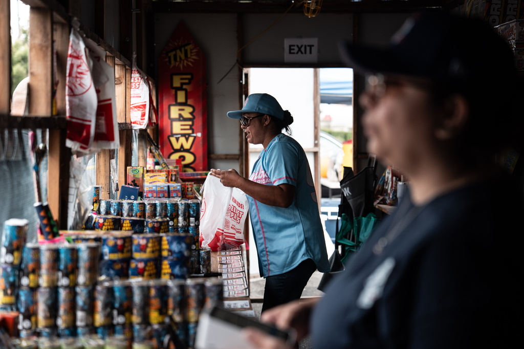 Volunteers Laurene Cardoza, foreground, and Jennifer Aragon work at a TNT Fireworks stand in Alhambra, Calif., Tuesday, June 30, 2026, ahead of the Fourth of July holiday. (AP Photo/Jae C. Hong)