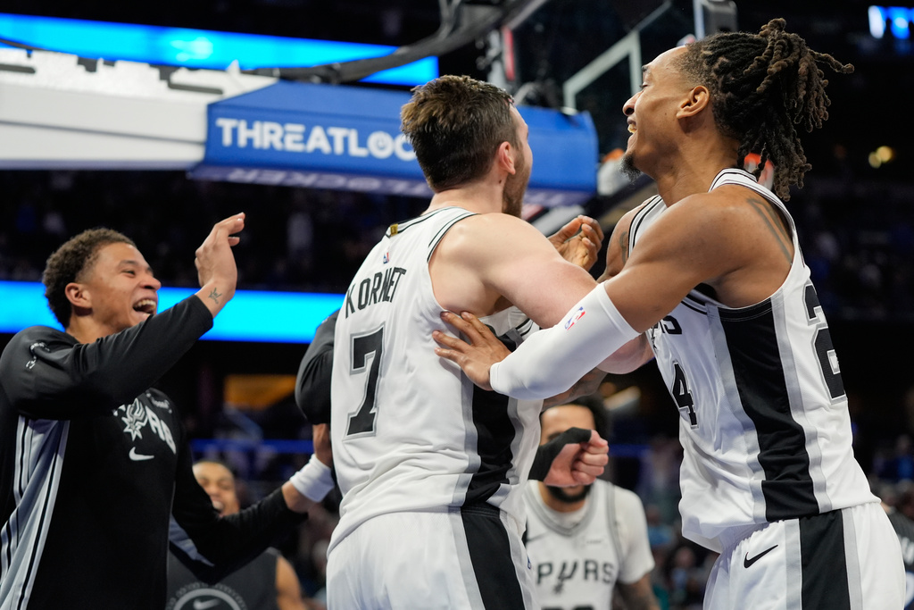 San Antonio Spurs center Luke Kornet (7) celebrates with teammates after blocking a shot by Orlando Magic forward Franz Wagner to win an NBA basketball game, Wednesday, Dec. 3, 2025, in Orlando, Fla. (AP Photo/John Raoux)