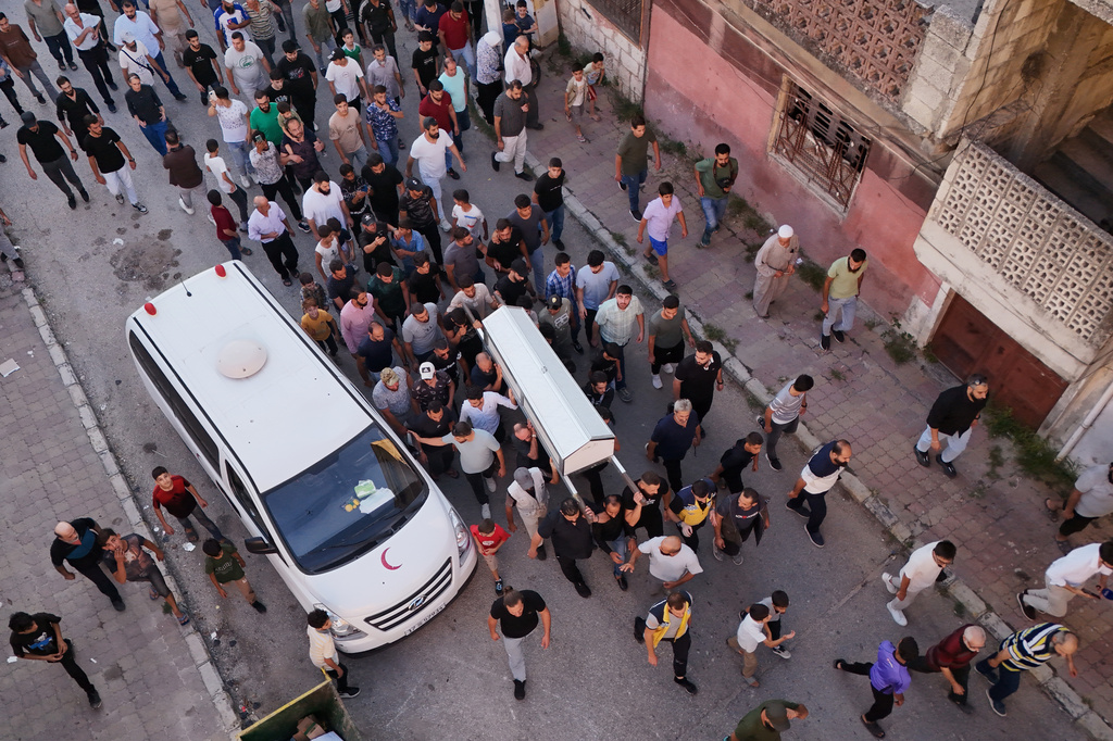 Mourners carry the coffin of Mohammad Ghamira, a former White Helmets volunteer who died shortly after his release from jail, for burial in the village of al-Haffa, in Latakia province, Syria, Monday, Aug. 17, 2026. (AP Photo)