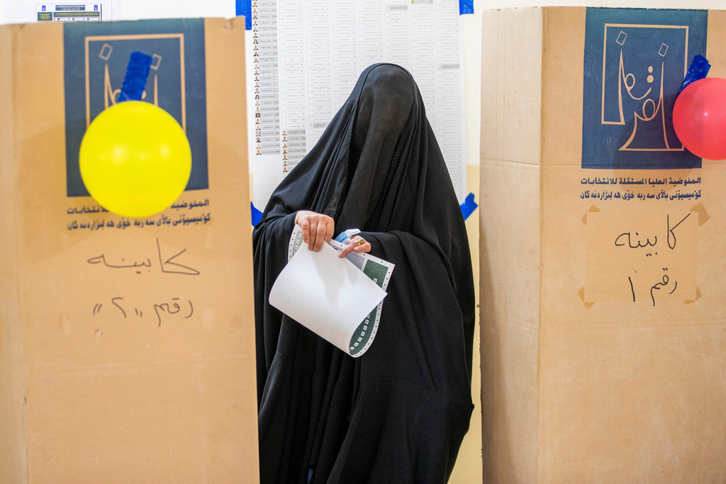 An Iraqi woman casts her vote in the country's parliamentary election at a polling center in Najaf, Iraq, Tuesday, Nov. 11, 2025. (AP Photo/Anmar Khalil)