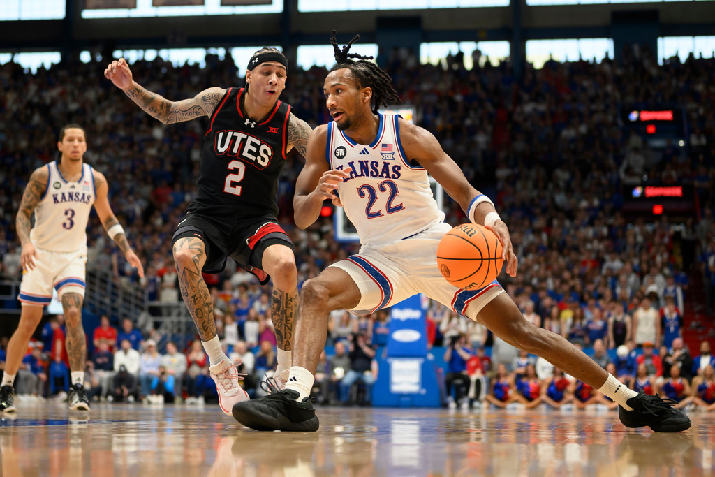 Kansas guard Darryn Peterson (22) drives against Utah guard Terrence Brown (2) during the first half of an NCAA college basketball game in Lawrence, Kan., Saturday, Feb. 7, 2026. (AP Photo/Reed Hoffmann)