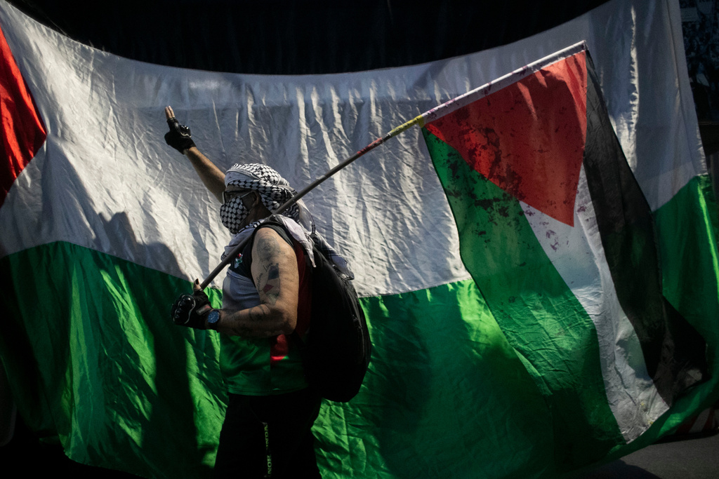 A man holds a Palestinian flag during a demonstration in solidarity with the Global Sumud Flotilla, in Rio de Janeiro, Wednesday, Oct. 2, 2025. (AP Photo/Bruna Prado)