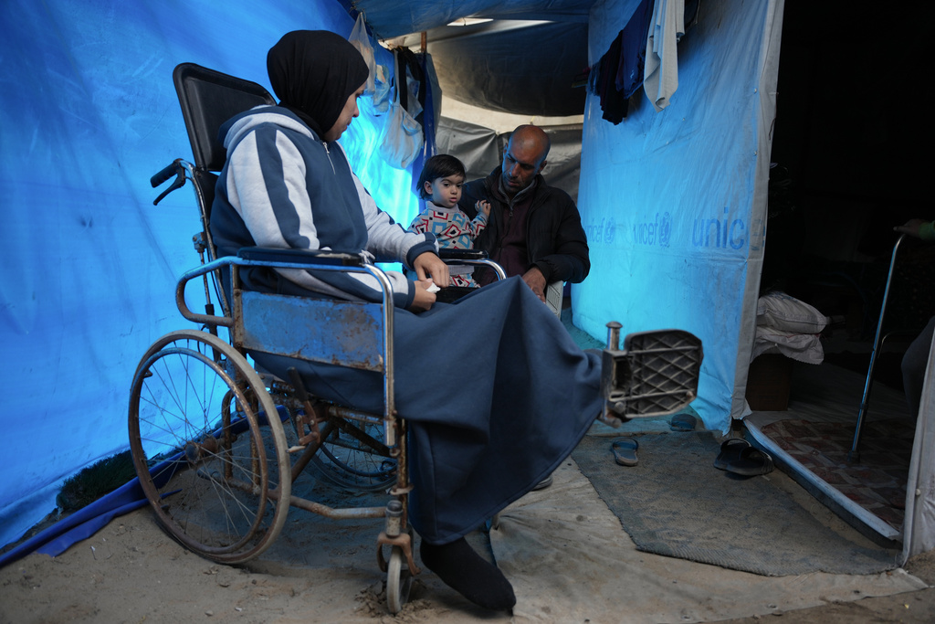 Islam Saleh, who was injured in her left leg in an Israeli strike on a school shelter in Jabalia in 2024, sits in a wheelchair inside her family's tent in Zawaida, Gaza Strip, Tuesday, Jan. 27, 2026, as she awaits permission to travel outside Gaza for treatment. (AP Photo/Abdel Kareem Hana)