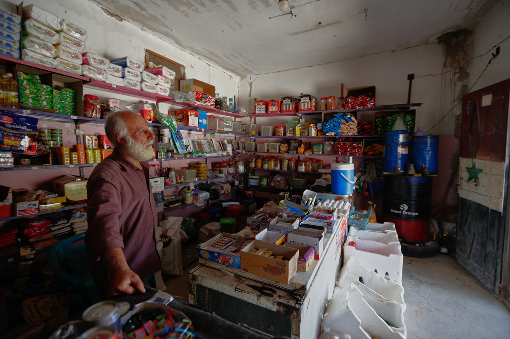 Mohammad al-Hassan stands inside his shop, stocked with food and household goods but empty of customers, in the village of Abdin, Daraa province, Syria, Monday, June 29, 2026. (AP Photo/Omar Sanadiki)