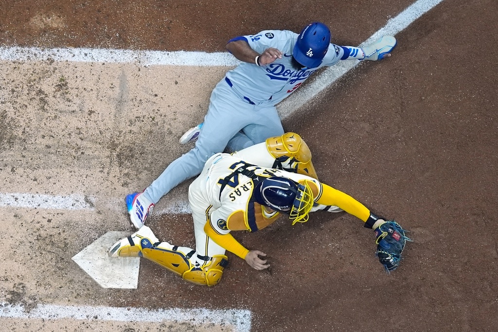 Los Angeles Dodgers' Teoscar Hernández is out at home as Milwaukee Brewers catcher William Contreras takes the throw during the fourth inning of Game 1 of baseball's National League Championship Series Monday, Oct. 13, 2025, in Milwaukee. (AP Photo/Morry Gash)