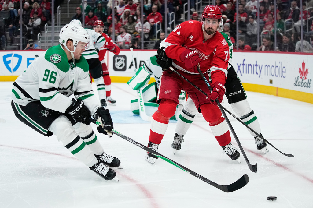 Detroit Red Wings center Dylan Larkin, right, moves the puck against Dallas Stars right wing Mikko Rantanen during the second period of an NHL hockey game Tuesday, Dec. 23, 2025, in Detroit. (AP Photo/Ryan Sun)
