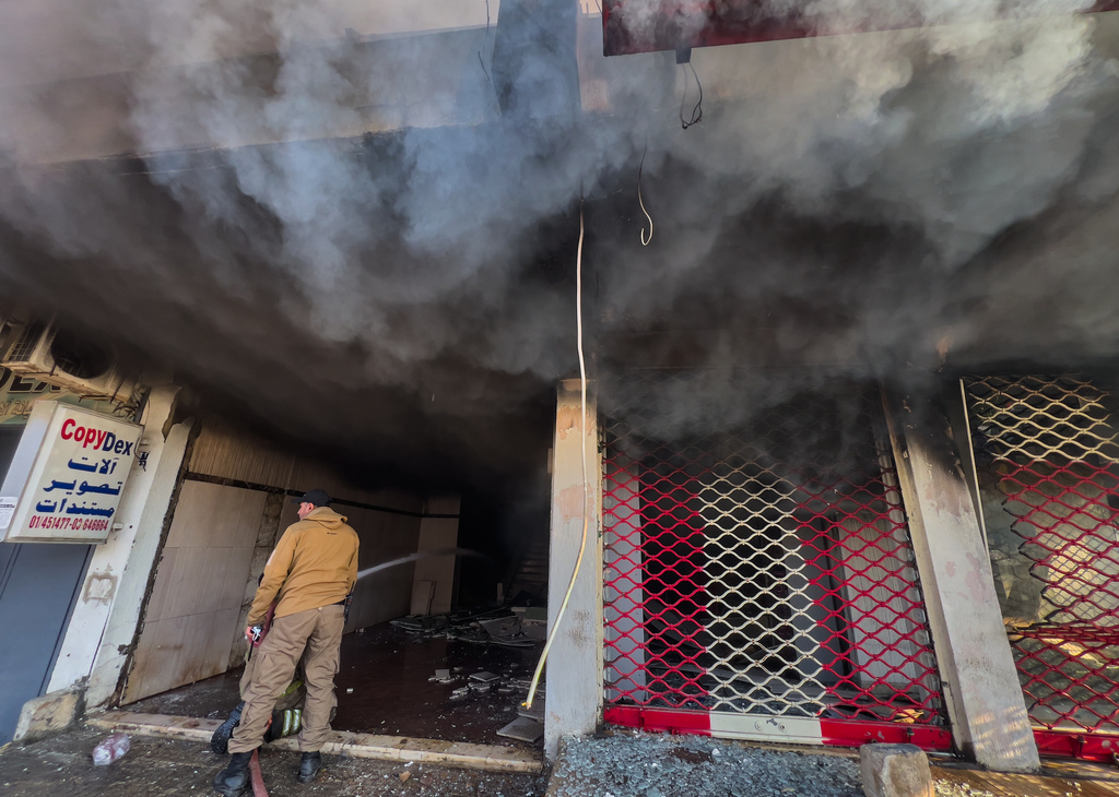 A firefighter extinguishes fire at a building that was hit by an Israeli airstrike in Dahiyeh, a southern suburb of Beirut, Lebanon, Tuesday, March 3, 2026. (AP Photo/Hussein Malla)
