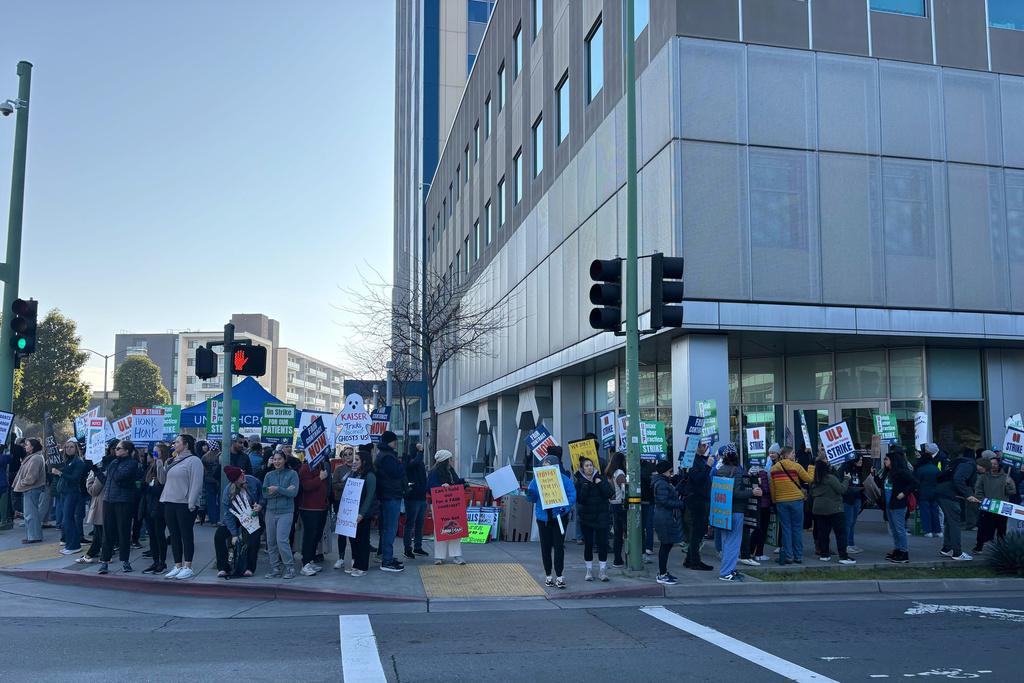 Kaiser Permanente nurses and health workers represented by the United Nurses Associations of California/Union of Health Care Professionals picket outside Kaiser's Oakland Medical Center on the first day of an open-ended strike Monday, Jan. 26, 2026, in Oakland, Calif. (Jessica Flores/San Francisco Chronicle via AP)