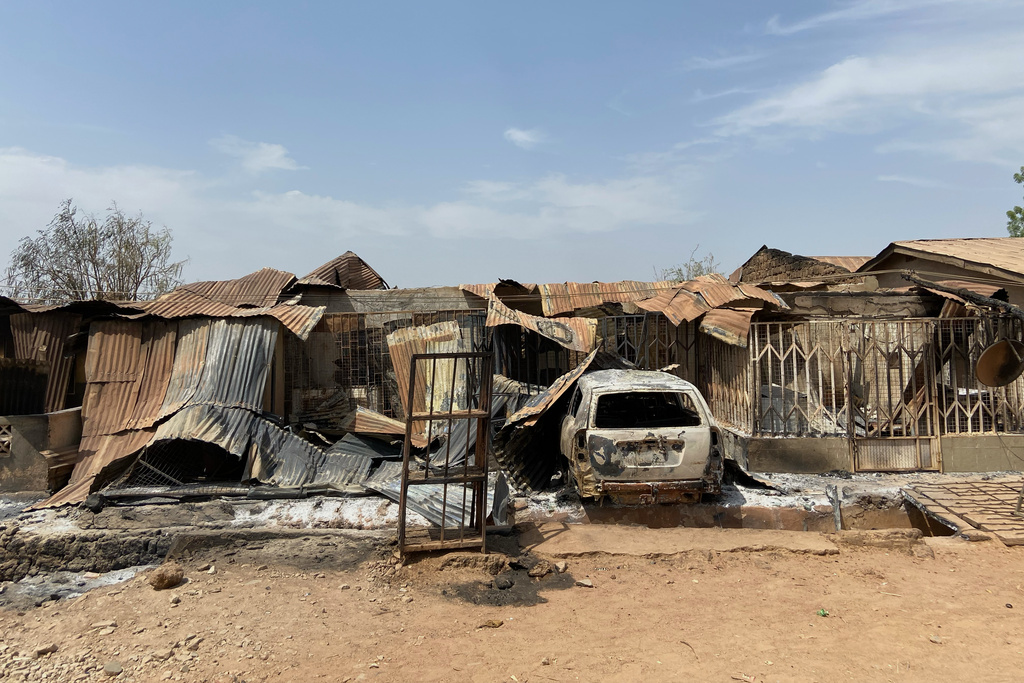 Charred homes and a vehicle stand in ruins days after an attack in the village of Woro, Nigeria, Thursday, Feb. 5, 2026. (AP Photo/Musa Salim)