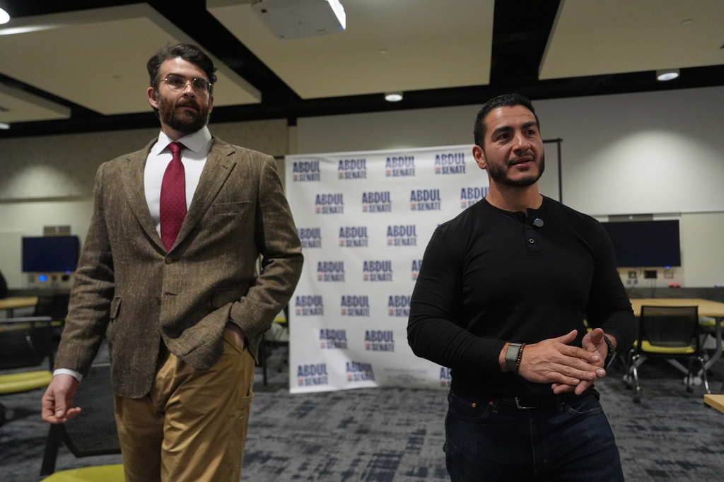 Hasan Piker, left, listens as Abdul El-Sayed, a progressive candidate in the Democratic primary for U.S. Senate in Michigan, speaks in a green room before a campaign rally, Tuesday, April 7, 2026, at the University of Michigan in Ann Arbor, Mich. (AP Photo/Julia Demaree Nikhinson)