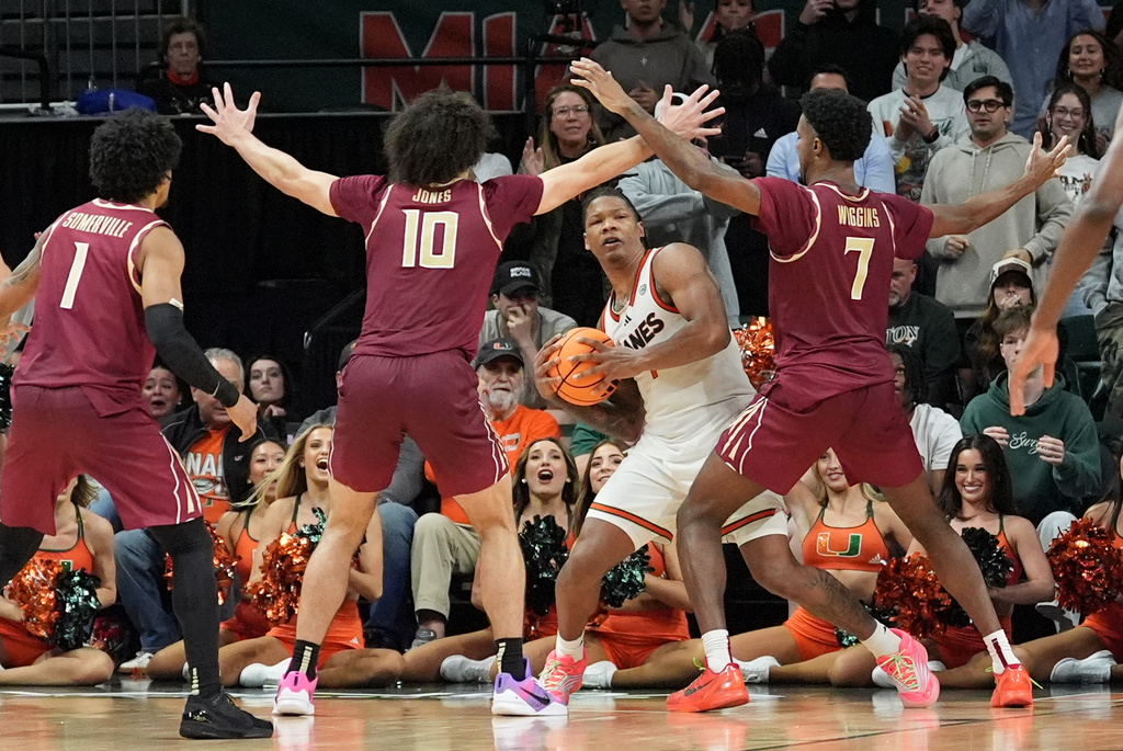 Miami forward Shelton Henderson, center right, looks for an opening through the defense of Florida State forward Chauncey Wiggins (7), guard Lajae Jones (10), and guard Martin Somerville (1) during the second half of an NCAA college basketball game, Tuesday, Jan. 20, 2026, in Coral Gables, Fla. (AP Photo/Rebecca Blackwell)
