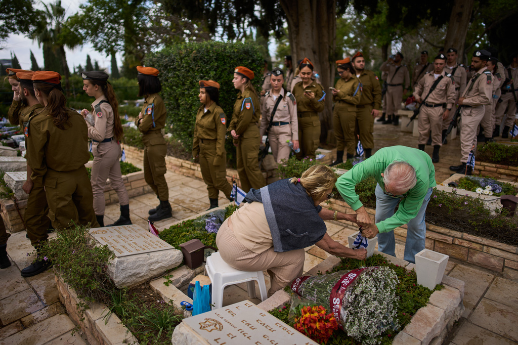 Israeli soldiers and relatives visit a military cemetery ahead of the annual Memorial Day honoring fallen soldiers and victims of nationalistic attacks in Tel Aviv, Israel, Monday, April 20, 2026. (AP Photo/Oded Balilty)