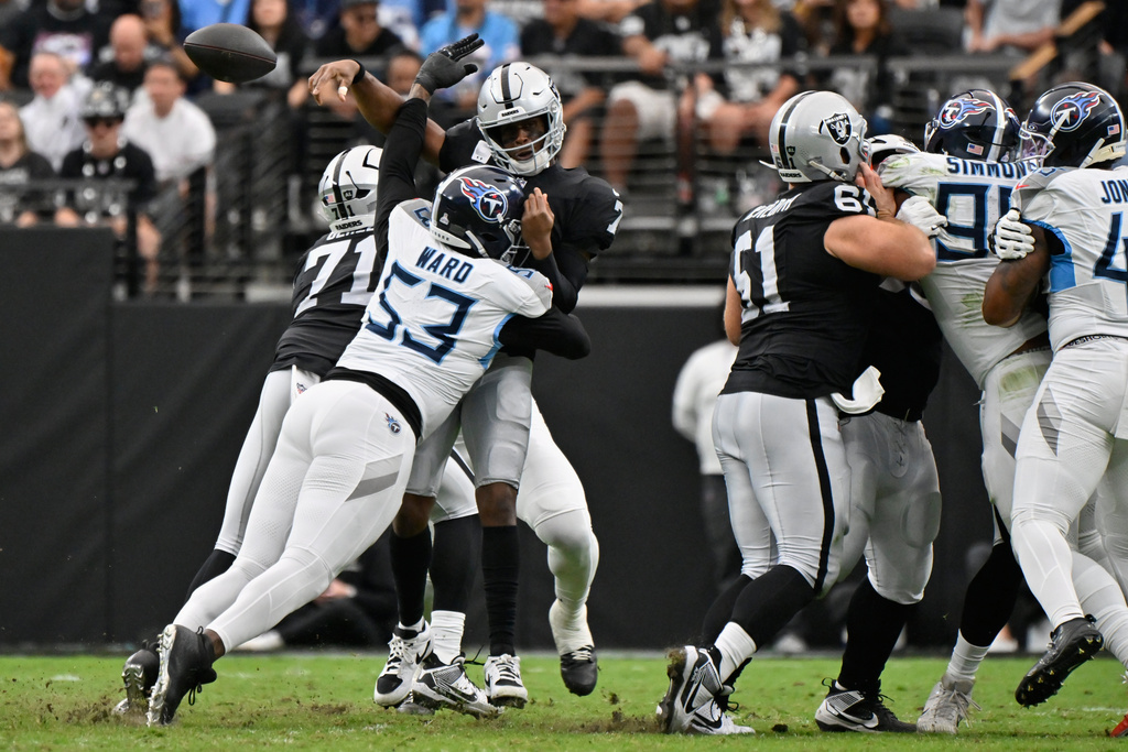 Las Vegas Raiders quarterback Geno Smith (7) throws an incomplete pass pressured by Tennessee Titans linebacker Jihad Ward (53) during the first half of an NFL football game, Sunday, Oct. 12, 2025, in Las Vegas. (AP Photo/David Becker)