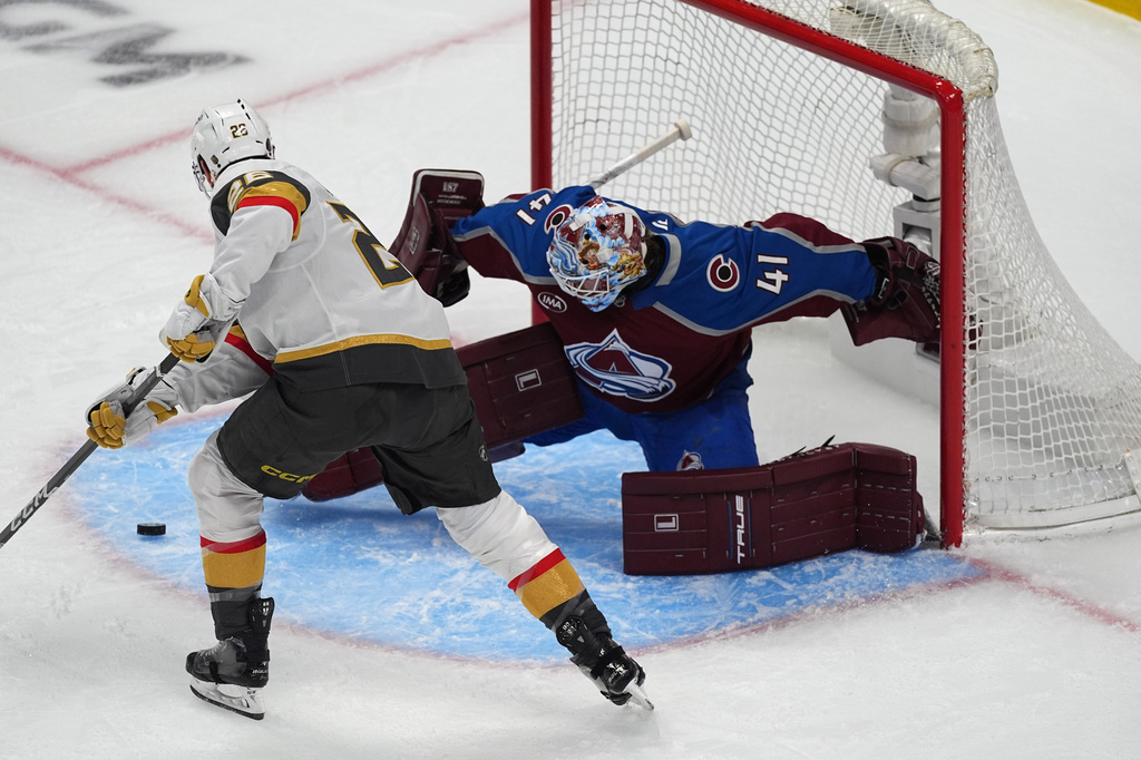 Vegas Golden Knights center Nic Dowd, left, puts a shot on Colorado Avalanche goaltender Scott Wedgewood during the first period in Game 2 of the Western Conference finals NHL hockey Stanley Cup playoff series Friday, May 22, 2026, in Denver. (AP Photo/David Zalubowski)