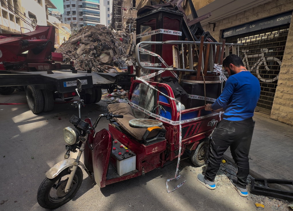 A worker arranges furniture from an apartment of a destroyed building that was hit a week ago in an Israeli airstrike in central Beirut, Lebanon, Thursday, April 16, 2026. (AP Photo/Hussein Malla)