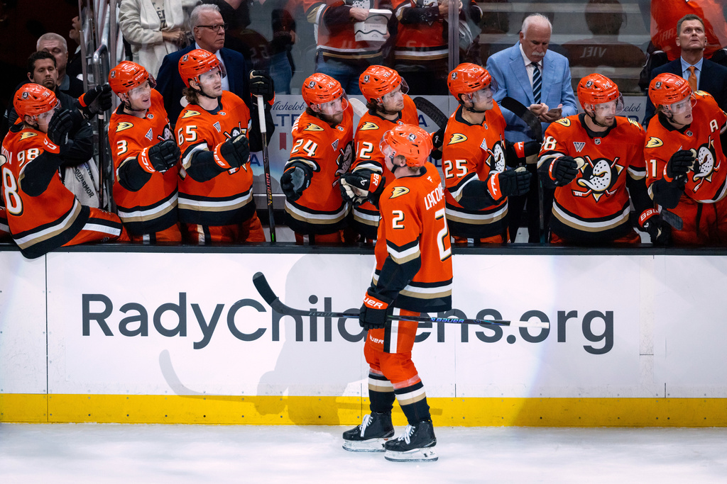 Anaheim Ducks defenseman Jackson LaCombe (2) is cheered by teammates after scoring against the Buffalo Sabres during the first period of an NHL hockey game, Sunday, March 22, 2026, in Anaheim, Calif. (AP Photo/Ethan Swope)