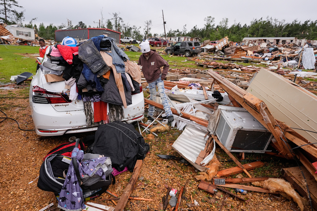 A person stands among debris at Gene's Mobile Home Supply, a trailer park in Bogue Chitto, Miss., Thursday, May, 7, 2026, after a tornado cut across the state. (AP Photo/Gerald Herbert)