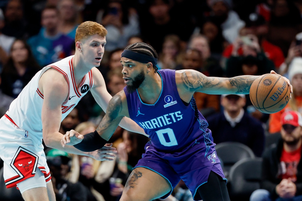 Charlotte Hornets forward Miles Bridges (0) drives against Chicago Bulls guard Kevin Huerter during the first half of an NBA Cup basketball game in Charlotte, N.C., Friday, Nov. 28, 2025. (AP Photo/Nell Redmond)