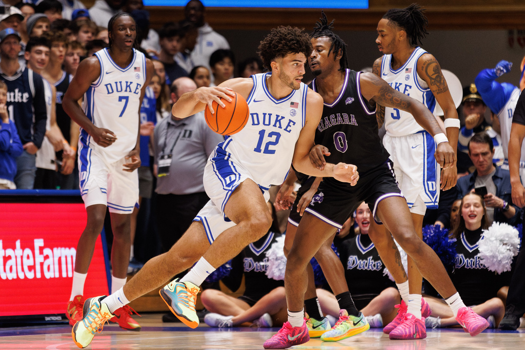 Duke's Cameron Boozer (12) handles the ball as Niagara's Justin Hawkins (0) defends during the first half of an NCAA college basketball game in Durham, N.C., Friday, Nov. 21, 2025. (AP Photo/Ben McKeown)