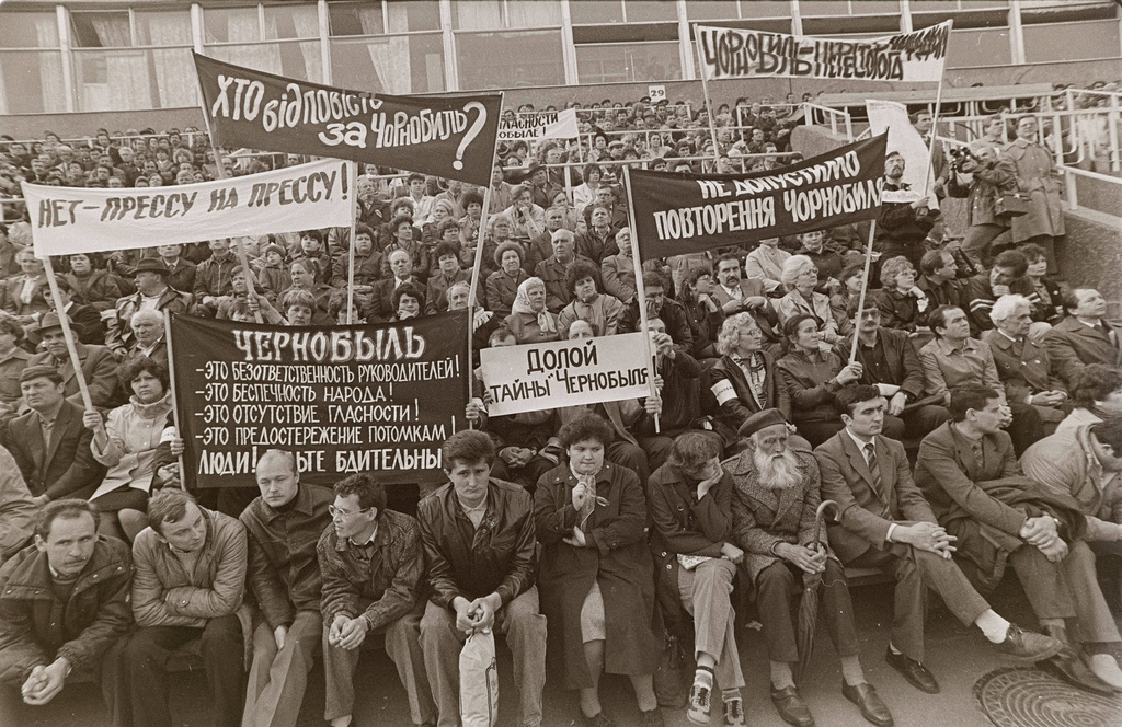 People hold signs reading "Down with the Chernobyl mysteries!" and "Who is responsible for Chernobyl?" during a protest rally demanding the truth about the Chernobyl nuclear power plant accident at a stadium in Chernobyl, Ukraine, April 26, 1989, on the third anniversary of the disaster. (AP Photo/Efrem Lukatsky)