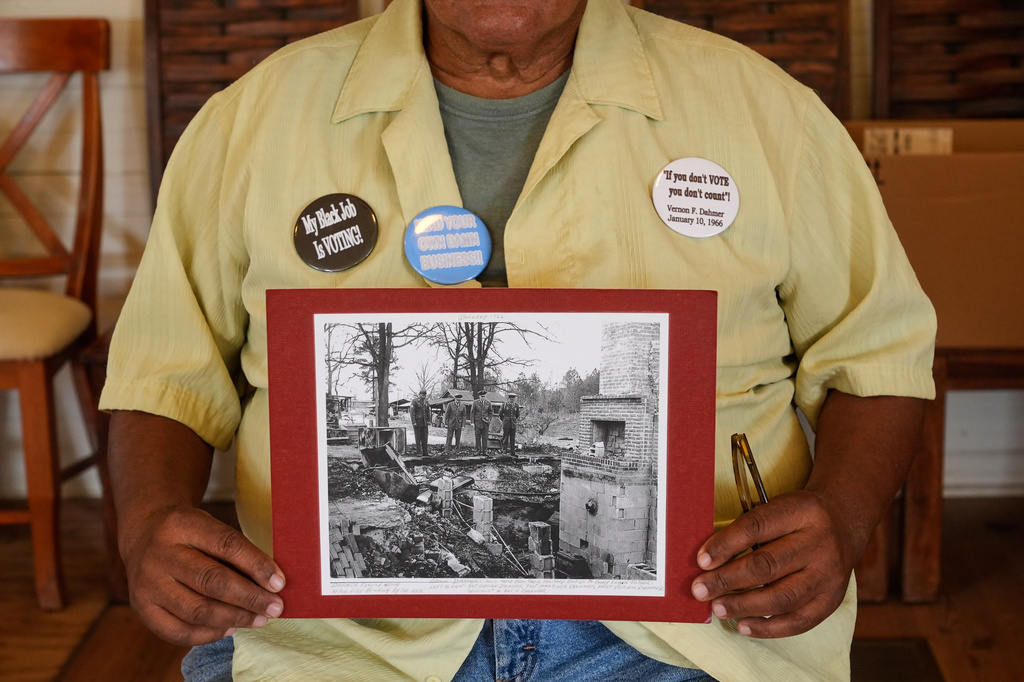 Dennis Dahmer, whose father Vernon Dahmer, Sr. was killed when the Ku Klux Klan firebombed the family home 1966, holds a photo of his brothers as they overlook the destroyed home after, after retiring home from military service, in Hattiesburg, Miss., Wednesday, June 3, 2026. (AP Photo/Gerald Herbert)