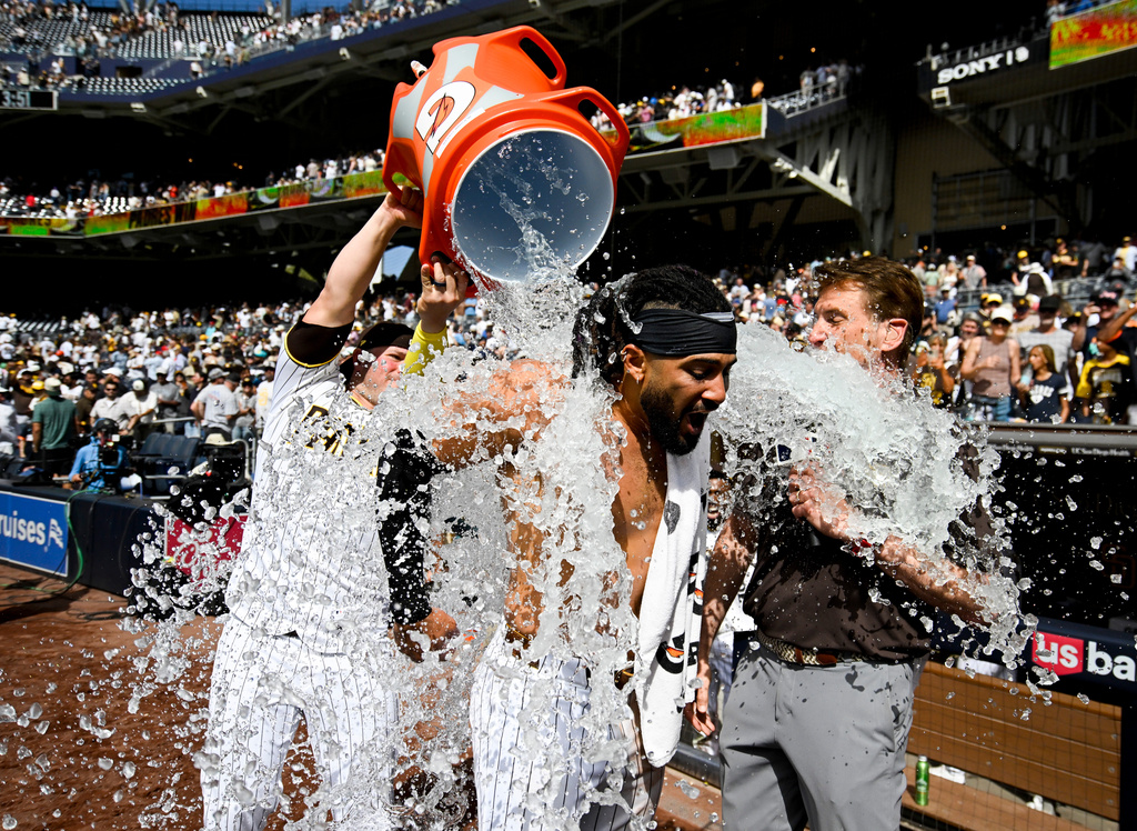 San Diego Padres' Fernando Tatis Jr. has a cooler dumped over him by Ty France after he hit a walk-off home run during a baseball game against the Cincinnati Reds, Wednesday, June 10, 2026, in San Diego. (AP Photo/Denis Poroy)