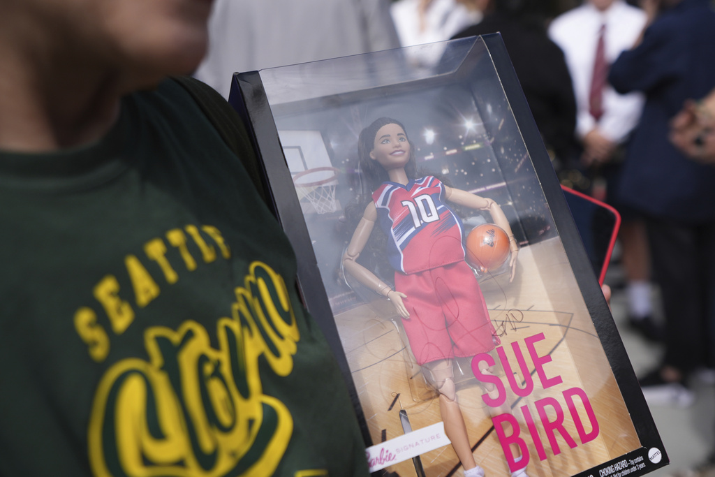 A fan holds a Barbie of Former Seattle Storm WNBA basketball point guard Sue Bird during the unveiling of her statue outside Climate Pledge Arena, Sunday, Aug. 17, 2025, in Seattle. (AP Photo/Lindsey Wasson)