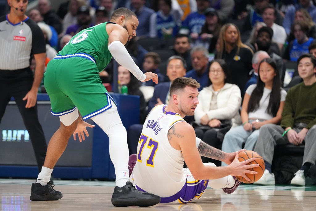 Los Angeles Lakers guard Luka Doncic (77) controls the ball against Dallas Mavericks forward Caleb Martin during the first half of an NBA basketball game Saturday, Jan. 24, 2026, in Dallas. (AP Photo/Julio Cortez)