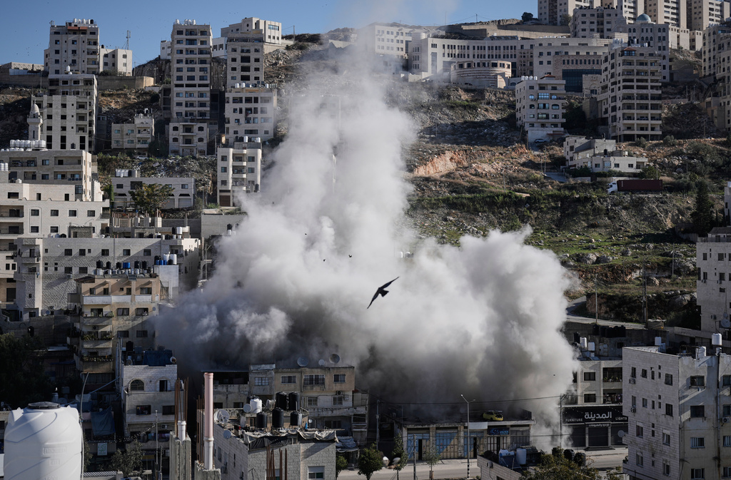 Smoke rises as Israeli forces demolish the home of Abdul Karim Sanoubar, a suspected Palestinian militant who has been accused by Israel of planting bombs on buses in central Israel, in Nablus, West Bank, Tuesday, Dec. 2, 2025. (AP Photo/Majdi Mohammed)