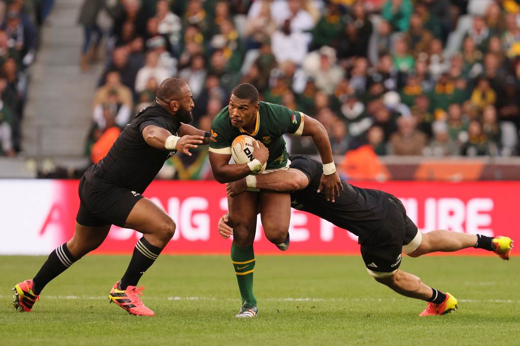 South Africa's Damian Willemse, center, is being tackled by New Zealand's Luke Jacobson, right, and his teammate George Bower during a second Test rugby match between South Africa and New Zealand, in Cape Town, South Africa, Saturday, Aug. 29, 2026. (AP Photo/Halden Krog)