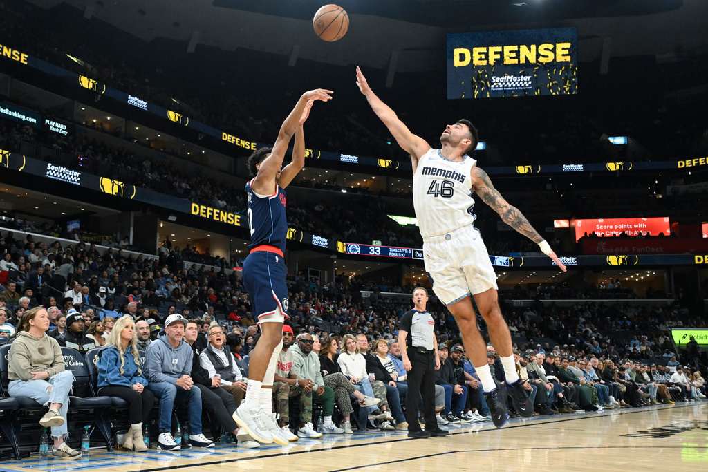 Los Angeles Clippers guard Cam Christie, left, shoots as Memphis Grizzlies guard John Konchar (46) defends during the first half of an NBA basketball game, Friday, Dec. 5, 2025, in Memphis, Tenn. (AP Photo/John Amis)