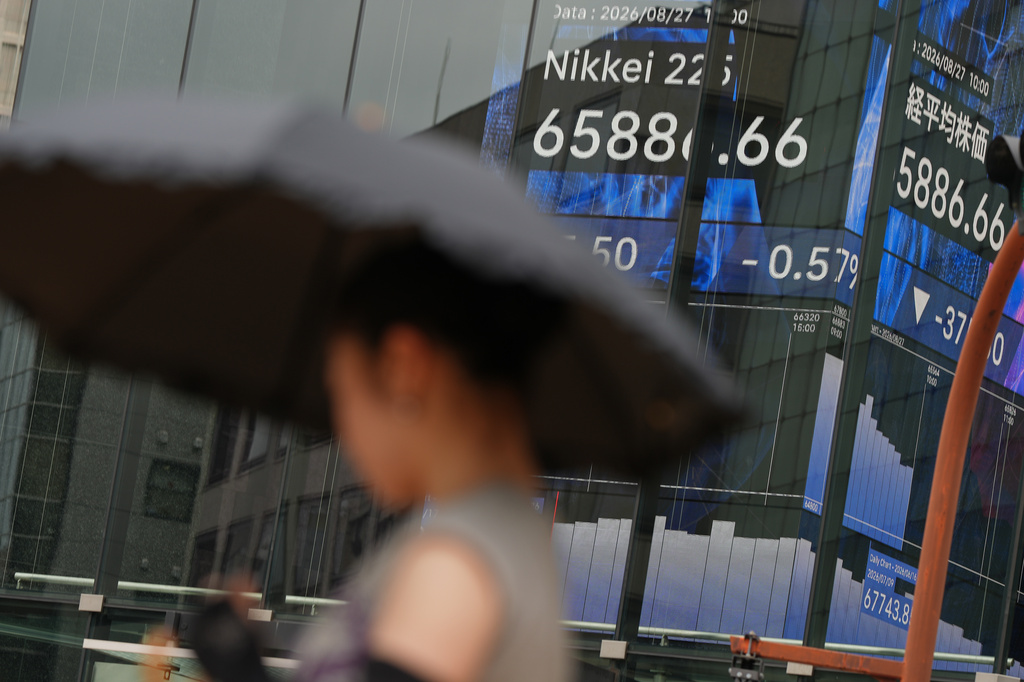 A person walks in front of an electronic stock board showing Japan's Nikkei index at a securities firm Thursday, Aug. 27, 2026, in Tokyo. (AP Photo/Eugene Hoshiko)