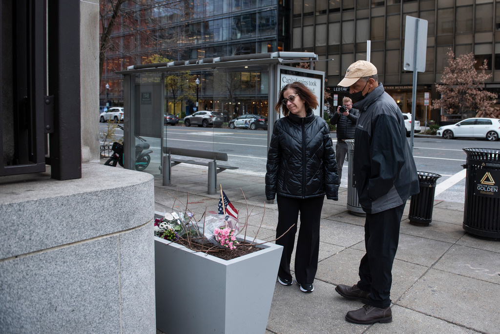 At the scene of the shooting, a couple looks at a memorial a day after two National Guard soldiers were shot near the White House in Washington, Thursday, Nov. 27, 2025. (AP Photo/Cliff Owen)