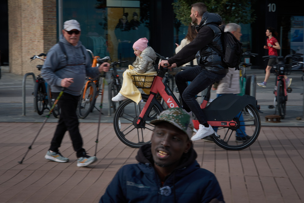 Alioune Beye, originally from Senegal, speaks during an interview with The Associated Press, while people stroll along the Barcelona seafront promenade, Spain, Thursday, Jan. 29, 2026. (AP Photo/Emilio Morenatti)