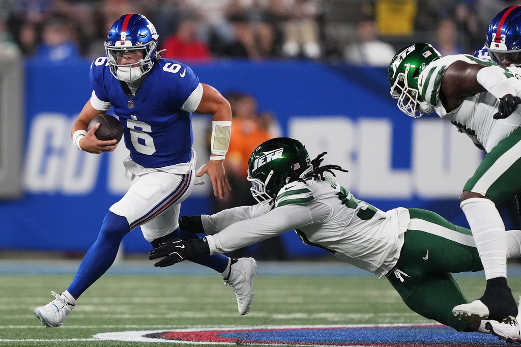 New York Giants quarterback Jaxson Dart (6) is sacked by New York Jets defensive end Kingsley Jonathan (57) during the second quarter of an NFL football game, Saturday, Aug. 16, 2025, in East Rutherford, N.J. (AP Photo/Yuki Iwamura)