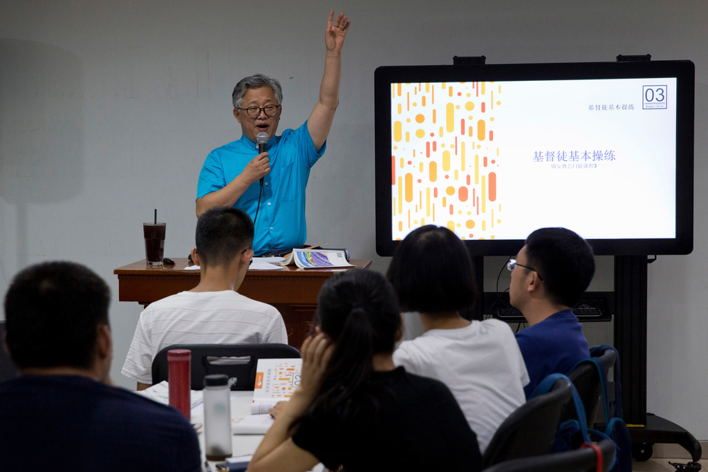FILE -In this photo taken Aug. 4, 2018, pastor Jin Minri leads a class on the basics of Christian beliefs at the Zion Church in Beijing, China. (AP Photo/Ng Han Guan), File)