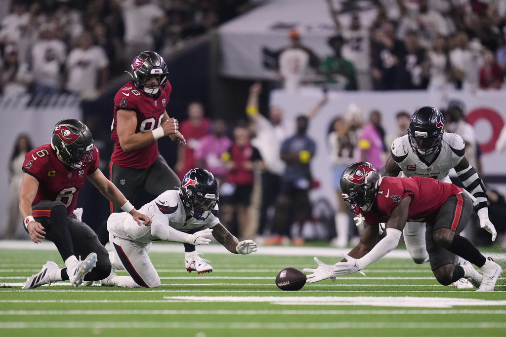 Tampa Bay Buccaneers running back Rachaad White, right, recovers a fumble by Baker Mayfield, left, in the second half of an NFL football game against the Houston Texans Monday, Sept. 15, 2025, in Houston, Texas. (AP Photo/Eric Christian Smith)