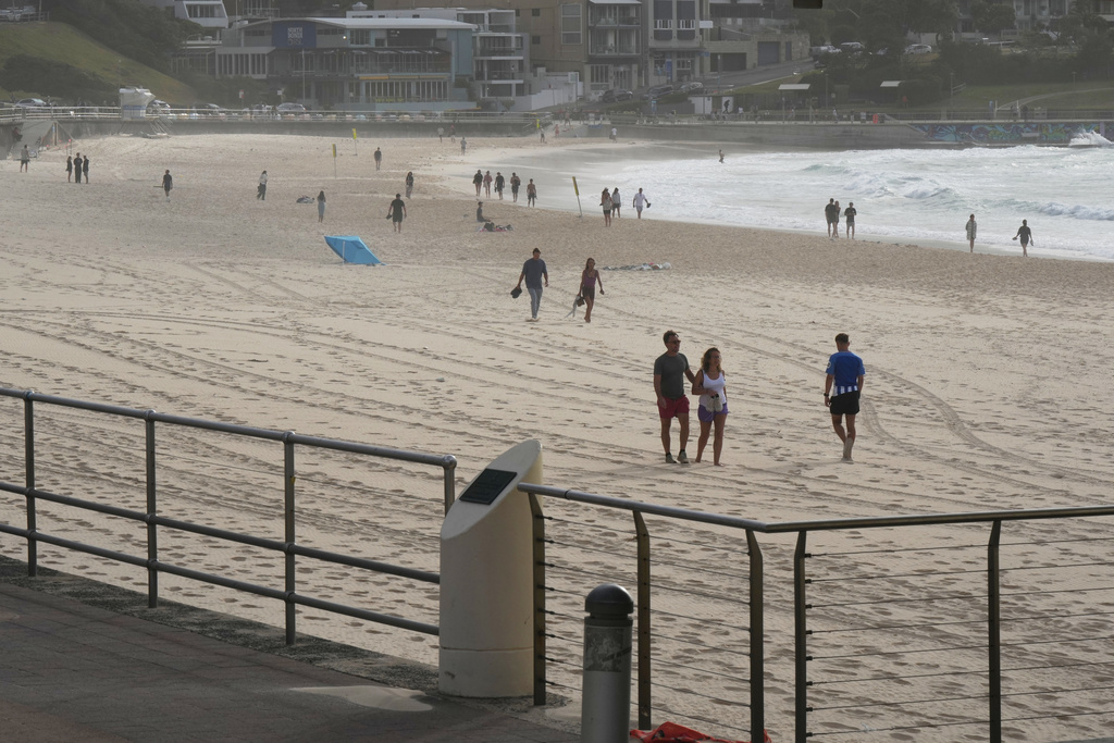 People walk along Sydney's Bondi Beach a day after a mass shooting Monday, Dec. 15, 2025. (AP Photo/Mark Baker)