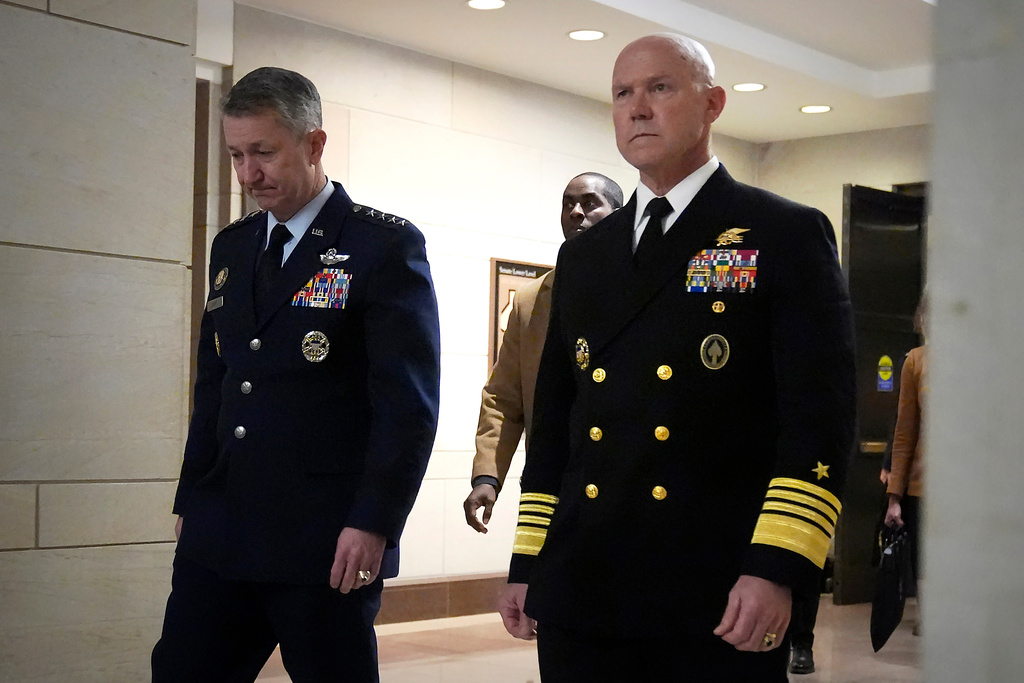 U.S. Navy Adm. Frank M. Bradley, right, accompanied by Gen. Dan Caine, chairman of the Joint Chiefs of Staff, left, walks to a meeting with senators on Capitol Hill, Thursday, Dec. 4, 2025, in Washington. (AP Photo/Mark Schiefelbein)
