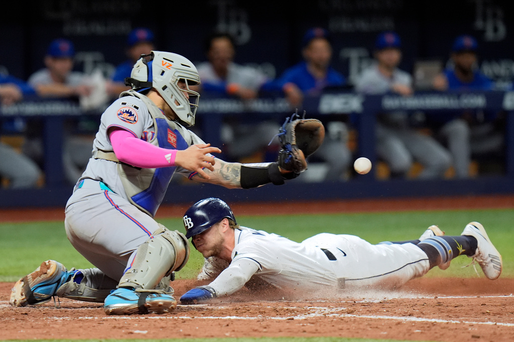 Tampa Bay Rays' Taylor Walls scores ahead of the throw to New York Mets catcher Francisco Alvarez on an RBI single by Liam Hicks during the eighth inning of a baseball game Monday, Aug. 31, 2026, in St. Petersburg, Fla. (AP Photo/Chris O'Meara)