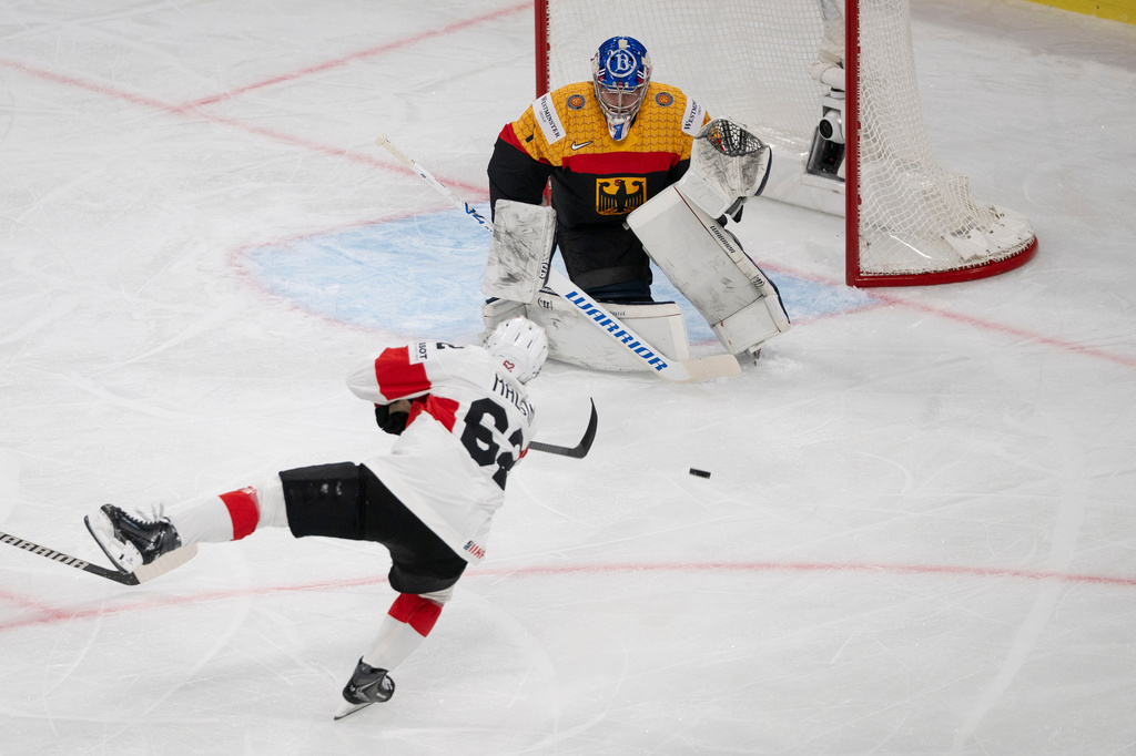 Switzerland's Denis Malgin, left, with a shoot against Germany's goaltender Jonas Stettmer, right, during the 2026 IIHF Men's Ice Hockey World Championship preliminary round group A game between Germany and Switzerland, in Zurich, Switzerland, Monday, May 18, 2026. (Andreas Becker/Keystone via AP)