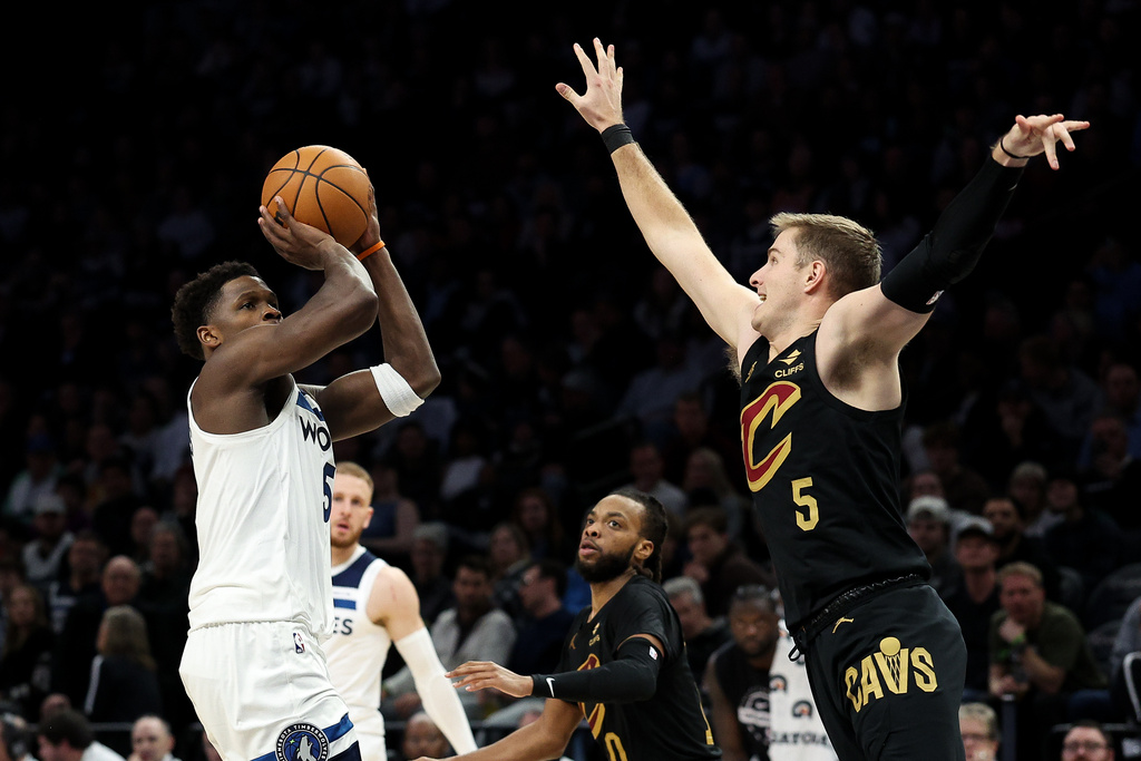 Minnesota Timberwolves guard Anthony Edwards, left, shoots over Cleveland Cavaliers guard Sam Merrill (5) during the second half of an NBA basketball game, Thursday, Jan. 8, 2026, in Minneapolis. (AP Photo/Matt Krohn)