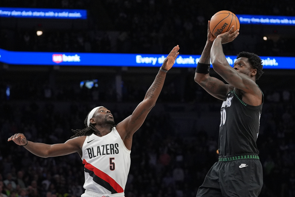 Minnesota Timberwolves forward Julius Randle, right, looks to shoot over Portland Trail Blazers guard Jrue Holiday (5) during the first half of an NBA basketball game, Friday, March 20, 2026, in Minneapolis. (AP Photo/Abbie Parr)