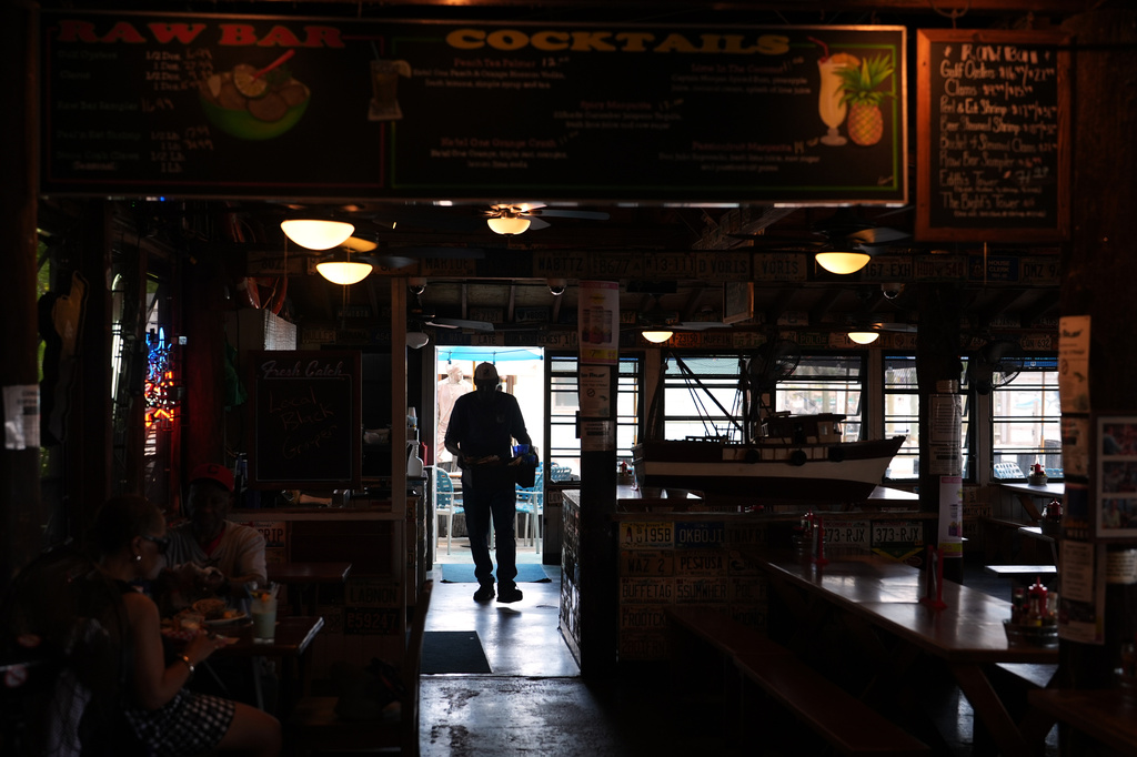 A Haitian worker with Temporary Protected Status busses tables at Half Shell Raw Bar, Friday, July 24, 2026, in Key West, Fla.(AP Photo/Rebecca Blackwell)