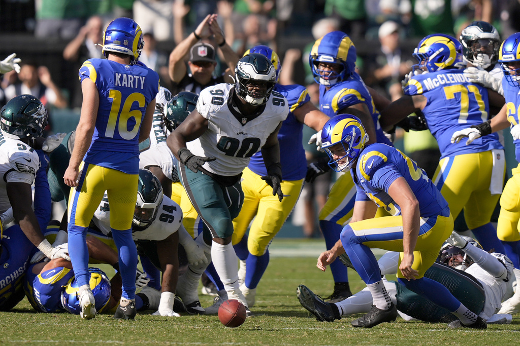 Philadelphia Eagles defensive tackle Jordan Davis (90) prepares to pick up the ball after blocking a field goal attempt by Los Angeles Rams kicker Joshua Karty (16) and run the ball back for a touchdown as time expires during the second half of an NFL football game against the Los Angeles Rams Sunday, Sept. 21, 2025, in Philadelphia. (AP Photo/Chris Szagola)