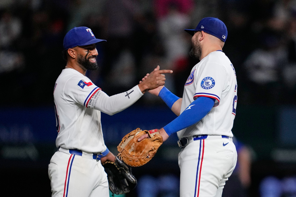 Texas Rangers' Ezequiel Duran, left, and Jake Burger, right, celebrate the team's win in a baseball game against the Arizona Diamondbacks Tuesday, May 12, 2026, in Arlington, Texas. (AP Photo/Tony Gutierrez)