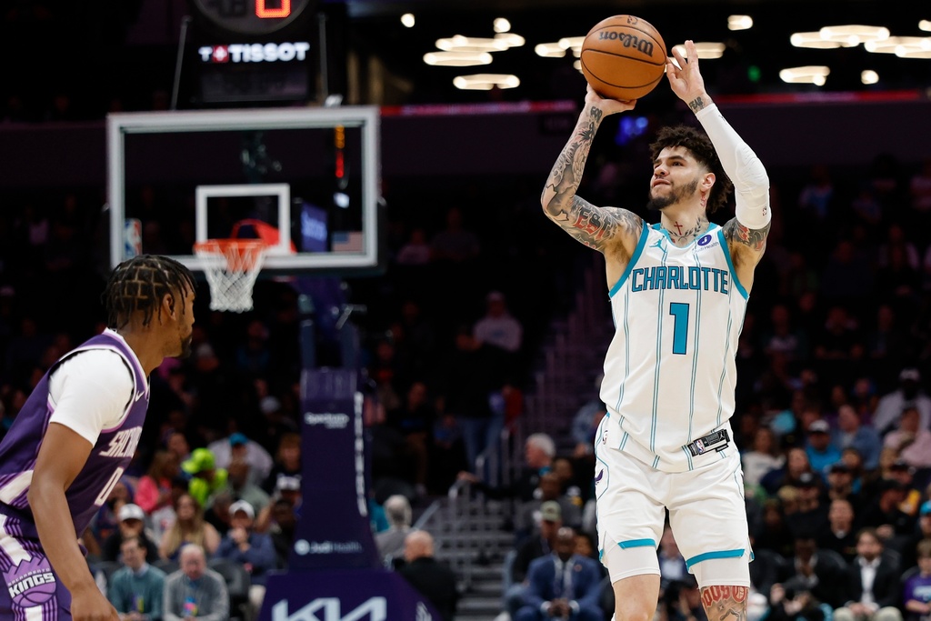 Charlotte Hornets guard LaMelo Ball (1) shoots over Sacramento Kings guard Malik Monk during the first half of an NBA basketball game in Charlotte, N.C., Tuesday, March 24, 2026. (AP Photo/Nell Redmond)